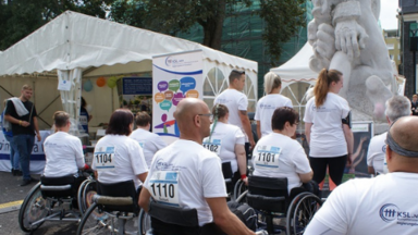 Rollstuhlfahrer*innen und Fußgänger*innen mit T-Shirts des KSL Düsseldorf 