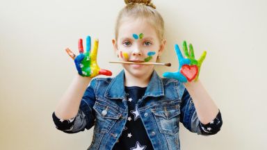 Das Mädchen hat bunte Hände.