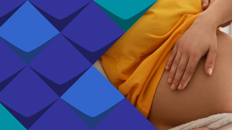 Eine Hebamme tastet den Bauch einer Schwangeren ab. 